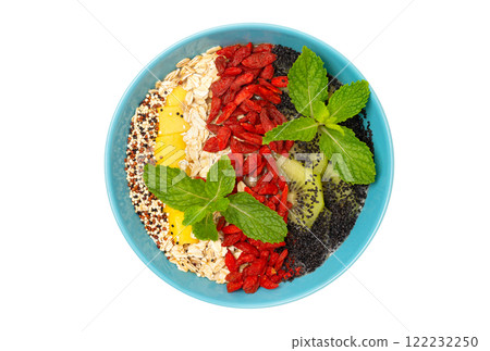 Top view image of sweet vegan superfood dessert as healthy lifestyle concept. Bowl of smoothie with kiwi, mango, oats, goji berries, quinoa and chia seeds isolated at white background. Top view image of sweet vegan superfood dessert as healthy lifestyle concept. Bowl of smoothie with kiwi, mango, oats, goji berries, quinoa and chia seeds isolated at white background. 122232250