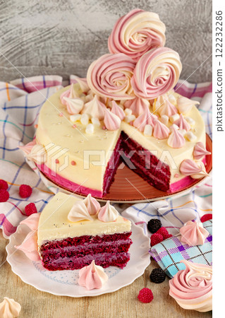 Plate of tasty sweet sponge cake with raspberry and meringue and a piece of cake at decorated with tablecloth table background. 122232286