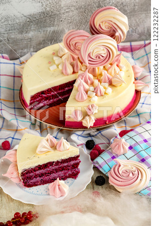 Plate of tasty sweet sponge cake with raspberry and meringue and a piece of cake at decorated with tablecloth table background. 122232287