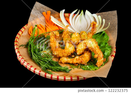 Group of crispy tempura fried shrimps served at plate with onion and carrot isolated at black background. 122232375
