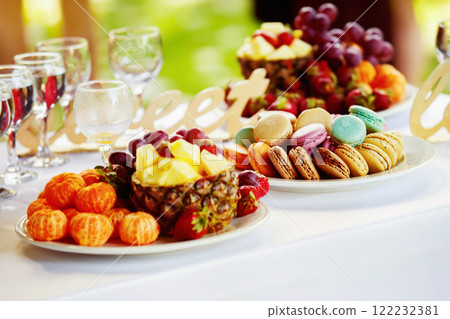 Closeup image of fresh fruits and berries and cookies at a white table background. 122232381
