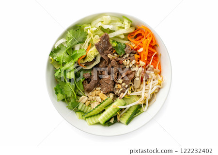 Closeup vietnamese healthy fresh salad of beef meat, bamboo, cabbage, cucumber and carrot served in a bowl isolated at white background. Closeup vietnamese healthy fresh salad of beef meat, bamboo, cabbage, cucumber and carrot served in a bowl isolated at white background. 122232402