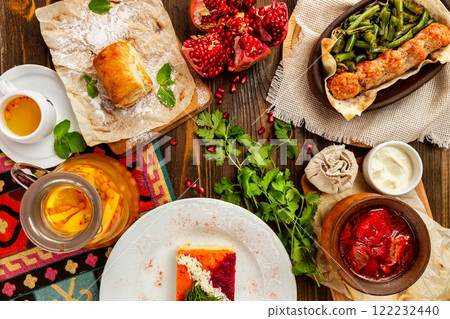 Top view image of traditional georgian lunch with various meals and ingredients at decorated wooden table background. 122232440