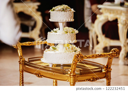 Image of tasty traditional wedding white cake with flowers figures. 122232451