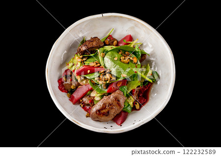 Plate of chicken liver salad with pear isolated at black background. 122232589