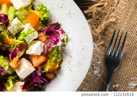 Fresh diet vegeterian salad decorated with herbs on wooden tray at table background. Fresh diet vegeterian salad decorated with herbs on wooden tray at table background. 122232618