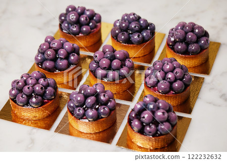 Closeup group of delicious tarts with berries served on golden paper. Restaurant sweet bakery. Closeup group of delicious tarts with berries served on golden paper. Restaurant sweet bakery. 122232632