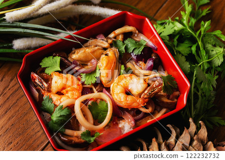Bowl of fried seafood cocktail with onion, bamboo and vegetables served at decorated wooden table background. Bowl of fried seafood cocktail with onion, bamboo and vegetables served at decorated wooden table background. 122232732