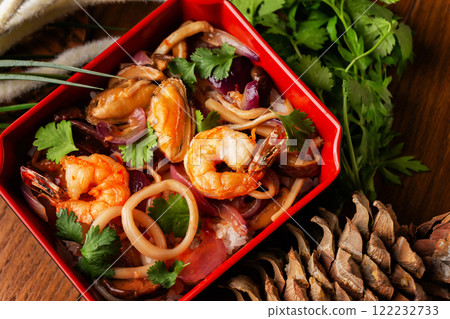 Bowl of fried seafood cocktail with onion, bamboo and vegetables served at decorated wooden table background. 122232733