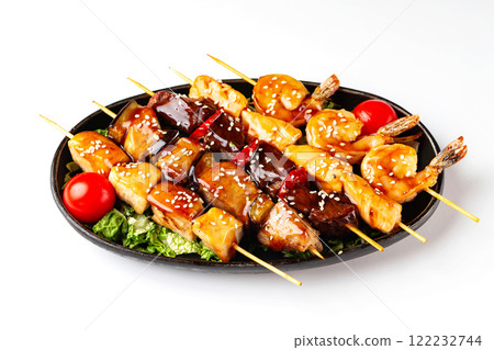 Closeup plate of grilled barbeque set of beef, porkm chicken, salmon and shrimps sticks isolated at white background. 122232744