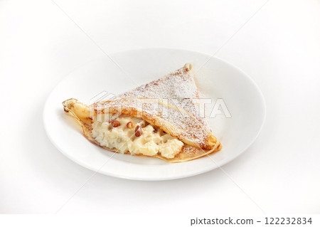 Image of fresh fried pancake plate decorated with sweet curds, raisins and sugar powder isolated on white background. 122232834