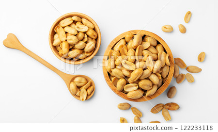 Peanuts in wooden bow with spoon isolated on white background 122233118
