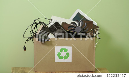 Paper Box with Sing Recycling, Old Electronic waste, phones, tablets, gadget devices for recycling. Planned Obsolescence, e-waste, electronic waste for Reuse Recycle Concept 122233437