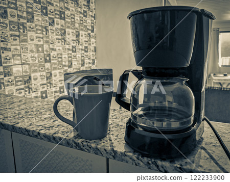 Coffee machine and red cup on table in the kitchen. 122233900