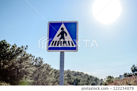 A pedestrian crossing sign standing in a field 122234879