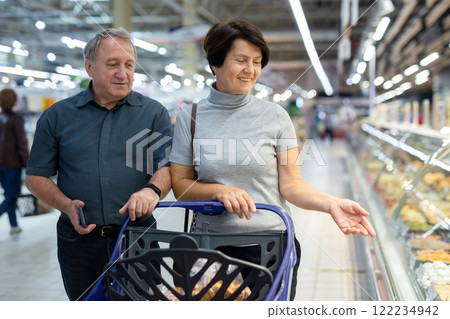 Elderly people walking through a supermarket to do their shopping 122234942