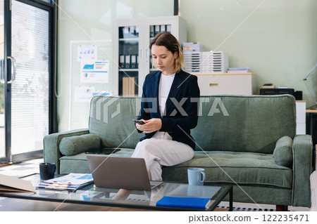 Businesswoman using mobile phone play social in office. 122235471
