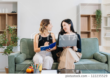 Office Lifestyle: Two Woman Reviews Business Project at Home Office. 122235529