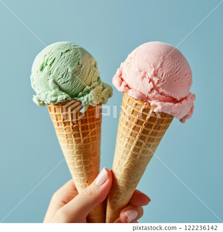 Two Ice Cream Cones in Hands on Pastel Background 122236142