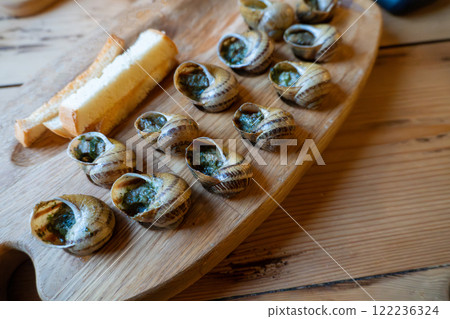 Escargot and bread on wooden tray: french culinary delicacy 122236324