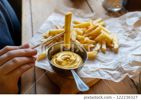 Crispy french fries with creamy cheese dip on rustic table Crispy french fries with creamy cheese dip on rustic table 122236327