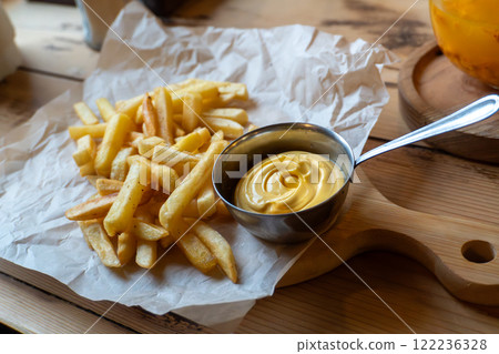 Crispy french fries with creamy mayonnaise on wooden board Crispy french fries with creamy mayonnaise on wooden board 122236328