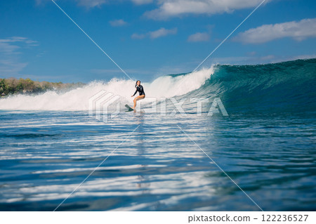 Female surfer riding a perfect wave on a sunny day and the beauty of surfing in ocean. Female surfer riding a perfect wave on a sunny day and the beauty of surfing in ocean. 122236527