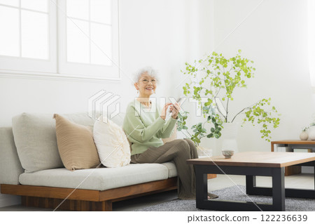 Senior woman making a phone call in the living room 122236639
