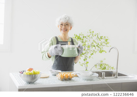 Grey-haired woman standing in the kitchen Grey-haired woman standing in the kitchen 122236646
