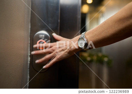 Pressing the elevator button in contemporary high rise buildings signifies modern urban convenience 122236989