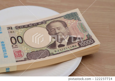 A stack of bills on a plate 122237714