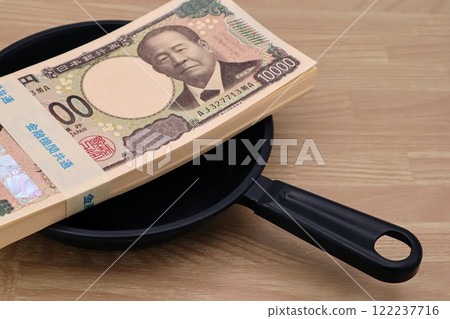 A stack of bills on a frying pan 122237716