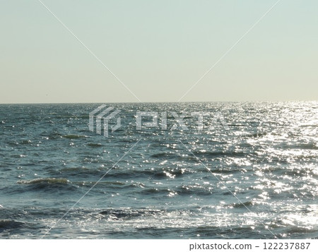 sunny calm sea water surface with ragged ripples on metallic colored waves, beautiful empty ocean landscape as wallpaper background sunny calm sea water surface with ragged ripples on metallic colored waves, beautiful empty ocean landscape as wallpaper background 122237887
