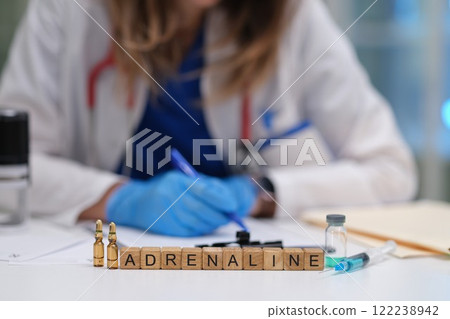 A medical professional meticulously preparing an adrenaline injection in a clinical setting 122238942