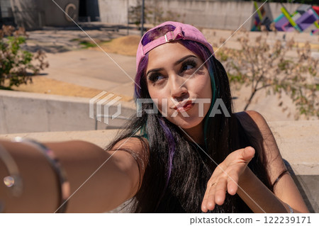 A smiling young woman taking a selfie on the street A smiling young woman taking a selfie on the street 122239171
