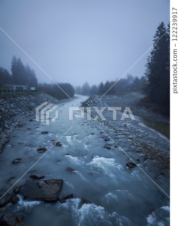 River arve flowing through misty chamonix valley in autumn 122239917
