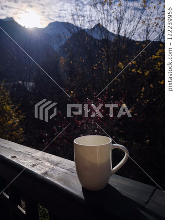 Steaming mug with coffee enjoying autumn sunrise in chamonix, french alps Steaming mug with coffee enjoying autumn sunrise in chamonix, french alps 122239956