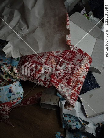 Christmas gift wrapping paper scattered on floor after presents opening Christmas gift wrapping paper scattered on floor after presents opening 122239994