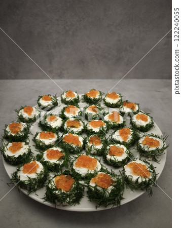 Delicious christmas canapes with red caviar and dill on cream cheese party food for aperitif, New Year's Eve dinner, Christmas or birthday Delicious christmas canapes with red caviar and dill on cream cheese party food for aperitif, New Year's Eve dinner, Christmas or birthday 122240055
