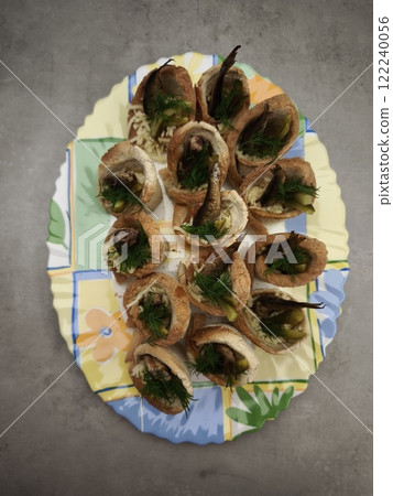 Christmas bread cups filled with sprats, pickles, and dill on festive plate in prague party food for aperitif, New Year's Eve dinner, Christmas or birthday 122240056