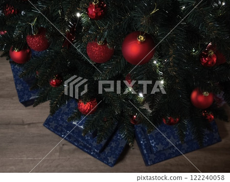 Christmas tree decorated with red baubles and blue gift boxes Gift boxes New Year preparation decor Christmas tree decorated with red baubles and blue gift boxes Gift boxes New Year preparation decor 122240058