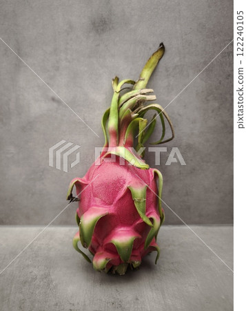 Vibrant pink dragon fruit resting on a gray surface in prague 122240105