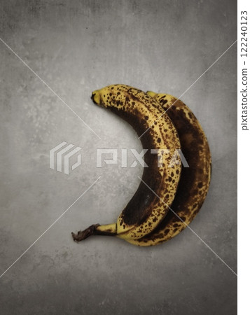 Two overripe bananas resting on gray surface in prague Two overripe bananas resting on gray surface in prague 122240123