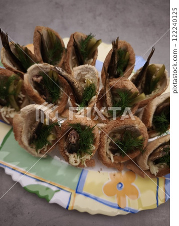 Christmas appetizer with sprats, dill, and bread baskets on a colorful plate in prague party food for aperitif, New Year's Eve dinner, Christmas or birthday 122240125