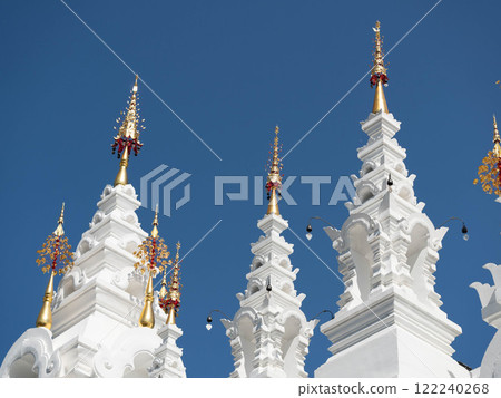 White and gold pagoda on a clear sky background in a Thai temple. 122240268