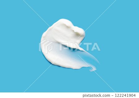 A sample of white cosmetic moisturizer on a blue background 122241904