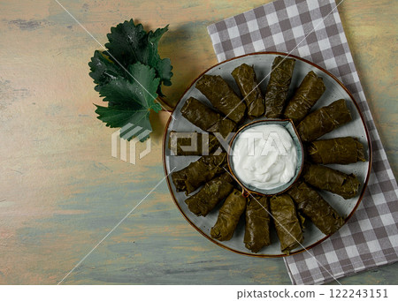 Dolma, cabbage rolls in grape leaves, Traditional Armenian dish, with white sauce, top view, close-up, selective focus, Dolma, cabbage rolls in grape leaves, Traditional Armenian dish, with white sauce, top view, close-up, selective focus, 122243151