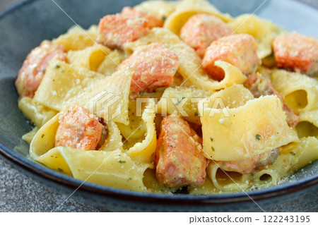 papardelle pasta, in creamy sauce with salmon, homemade, on a gray background, no people, 122243195