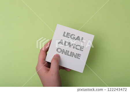 A hand holding a piece of paper with the words Legal Advice Online written on it 122243472