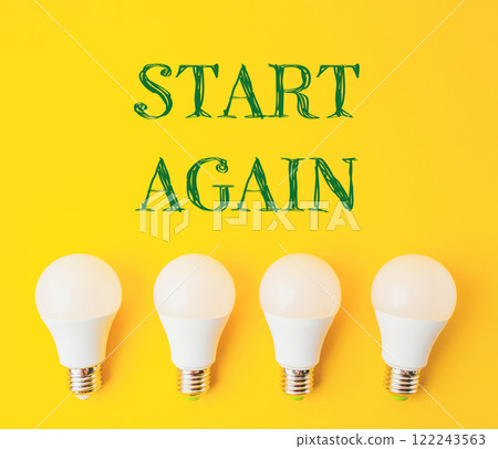 Four white light bulbs arranged in a row on a yellow background 122243563